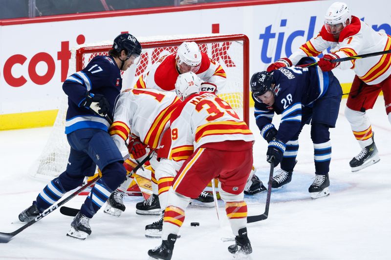 Oct 2, 2024; Winnipeg, Manitoba, CAN;  Winnipeg Jets forward Adam Lowry (17), Winnipeg Jets forward Jaret Anderson-Dolan (28), Calgary Flames forward Anthony Mantha (39), Calgary Flames defenseman Tyson Barrie (8) and Calgary Flames defenseman Kevin Bahl (7) search for the puck during the third period at Canada Life Centre. Mandatory Credit: Terrence Lee-Imagn Images