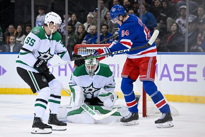 Jan 7, 2025; New York, New York, USA;  Dallas Stars goaltender Jake Oettinger (29) makes a save as Dallas Stars defenseman Nils Lundkvist (5)5 defends against New York Rangers center Adam Edstrom (84) during the third period at Madison Square Garden. Mandatory Credit: Dennis Schneidler-Imagn Images