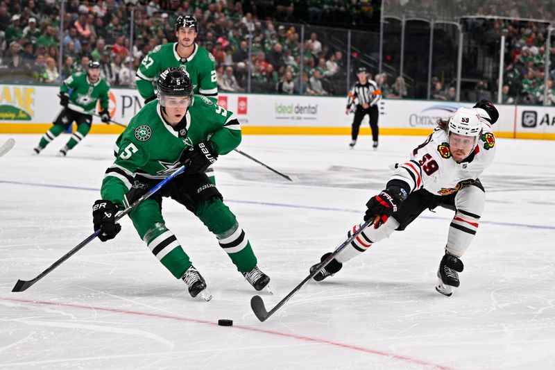 Oct 26, 2024; Dallas, Texas, USA; Dallas Stars defenseman Nils Lundkvist (5) and Chicago Blackhawks left wing Tyler Bertuzzi (59) chase the puck during the first period at the American Airlines Center. Mandatory Credit: Jerome Miron-Imagn Images