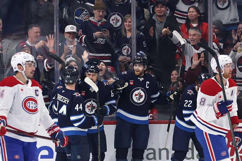 Dec 14, 2024; Winnipeg, Manitoba, CAN; Winnipeg Jets center Adam Lowry (17) celebrates his first period goal against the Montreal Canadiens at Canada Life Centre. Mandatory Credit: James Carey Lauder-Imagn Images