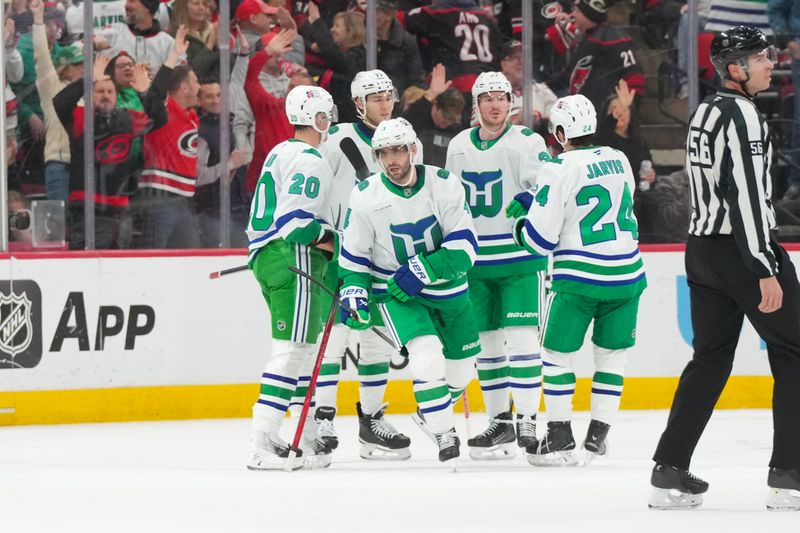 Jan 29, 2026; Raleigh, North Carolina, USA;  Carolina Hurricanes defenseman Shayne Gostisbehere (4) celebrates scoring against Utah Mammoth during the second period at Lenovo Center. Mandatory Credit: James Guillory-Imagn Images