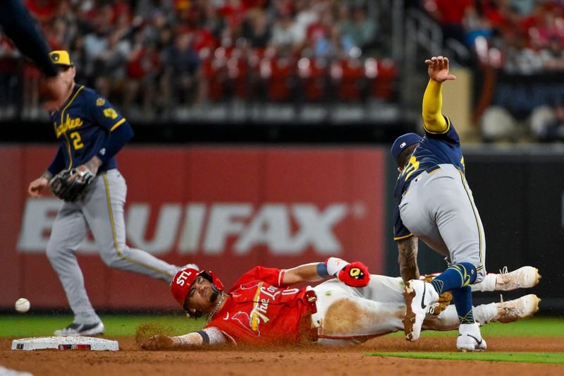 Apr 25, 2025; St. Louis, Missouri, USA;  St. Louis Cardinals shortstop Masyn Winn (0) slides safely past Milwaukee Brewers shortstop Joey Ortiz (3) for a stolen base during the fifth inning at Busch Stadium. Mandatory Credit: Jeff Curry-Imagn Images