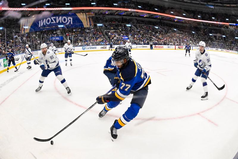 Nov 5, 2024; St. Louis, Missouri, USA;  St. Louis Blues defenseman Pierre-Olivier Joseph (77) controls the puck against the Tampa Bay Lightning during the second period at Enterprise Center. Mandatory Credit: Jeff Curry-Imagn Images