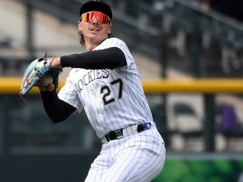 Apr 19, 2025; Denver, Colorado, USA; Colorado Rockies left fielder Jordan Beck (27) fields a ball during the seventh inning against the Washington Nationals at Coors Field. Mandatory Credit: Christopher Hanewinckel-Imagn Images