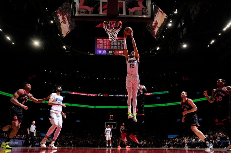 TORONTO, CANADA - JANUARY 3: Trevelin Queen #12 of the Orlando Magic dunks the ball during the game against the Toronto Raptors on January 3, 2025 at the Scotiabank Arena in Toronto, Ontario, Canada.  NOTE TO USER: User expressly acknowledges and agrees that, by downloading and or using this Photograph, user is consenting to the terms and conditions of the Getty Images License Agreement.  Mandatory Copyright Notice: Copyright 2025 NBAE(Photo by Mark Blinch/NBAE via Getty Images)