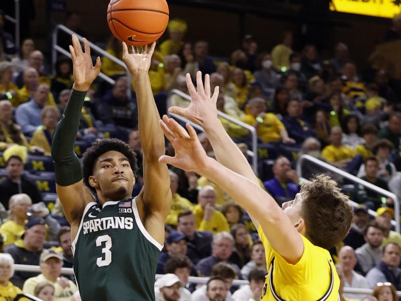 Feb 18, 2023; Ann Arbor, Michigan, USA;  Michigan State Spartans guard Jaden Akins (3) shoots the ball against Michigan Wolverines forward Will Tschetter (42) in the first half at Crisler Center. Mandatory Credit: Rick Osentoski-USA TODAY Sports