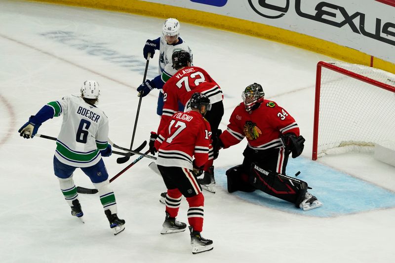 Oct 22, 2024; Chicago, Illinois, USA; Vancouver Canucks right wing Brock Boeser (6) scores a goal on Chicago Blackhawks goaltender Petr Mrazek (34) during the third period at United Center. Mandatory Credit: David Banks-Imagn Images