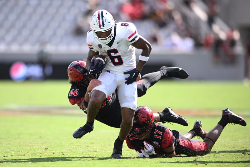 Sep 3, 2022; San Diego, California, USA; Arizona Wildcats running back Michael Wiley (6) is tackled by San Diego State Aztecs defensive lineman Jonah Tavai (66) during the second half at Snapdragon Stadium. Mandatory Credit: Orlando Ramirez-USA TODAY Sports