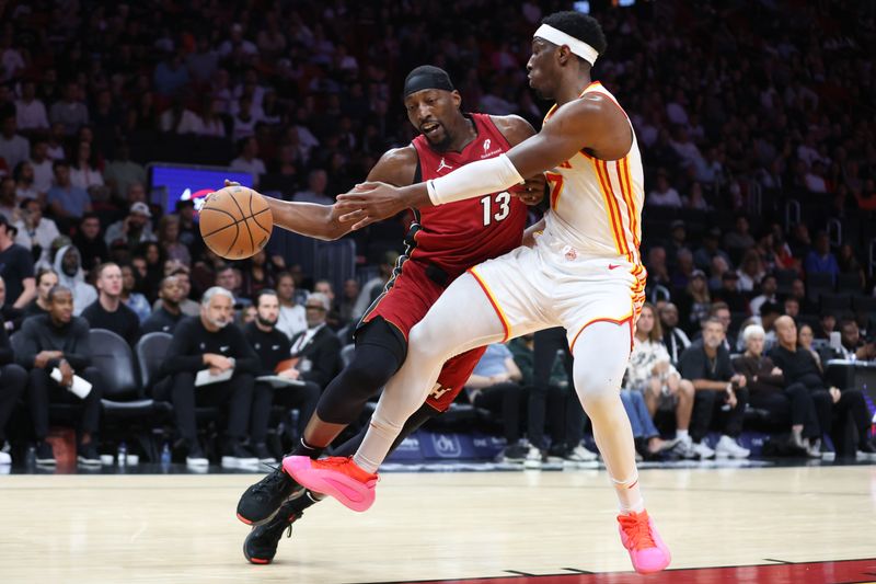 MIAMI, FLORIDA - FEBRUARY 26: Bam Adebayo #13 of the Miami Heat drives against Onyeka Okongwu #17 of the Atlanta Hawks during the third quarter of the game at Kaseya Center on February 26, 2025 in Miami, Florida. NOTE TO USER: User expressly acknowledges and agrees that, by downloading and or using this photograph, User is consenting to the terms and conditions of the Getty Images License Agreement. (Photo by Megan Briggs/Getty Images)