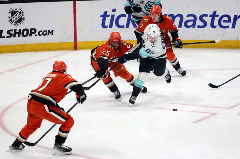 Dec 22, 2025; Anaheim, California, USA;  Seattle Kraken right wing Eeli Tolvanen (20) fights for the puck against Anaheim Ducks center Ryan Poehling (25) during the third period at Honda Center. Mandatory Credit: Kiyoshi Mio-Imagn Images