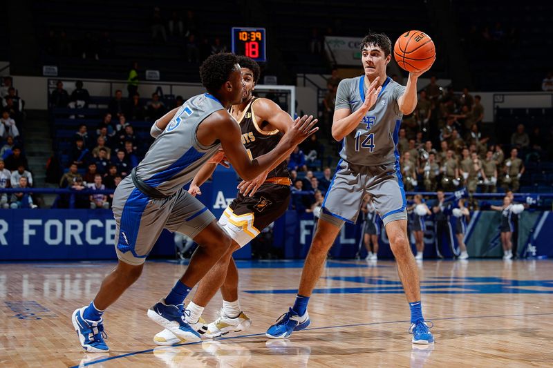 Jan 17, 2023; Colorado Springs, Colorado, USA; Air Force Falcons forward Beau Becker (14) passes the ball to guard Ethan Taylor (5) as Wyoming Cowboys forward Caden Powell (44) defends in the second half at Clune Arena. Mandatory Credit: Isaiah J. Downing-USA TODAY Sports