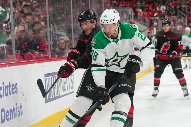 Jan 6, 2026; Raleigh, North Carolina, USA;  Dallas Stars defenseman Alexander Petrovic (28) and Carolina Hurricanes right wing Andrei Svechnikov (37) battle during the first period at Lenovo Center. Mandatory Credit: James Guillory-Imagn Images