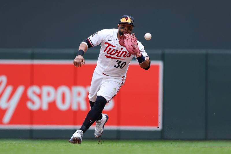 May 16, 2024; Minneapolis, Minnesota, USA; Minnesota Twins first baseman Carlos Santana (30) fields the ball hit by New York Yankees Anthony Rizzo (48) during the sixth inning at Target Field. Mandatory Credit: Matt Krohn-USA TODAY Sports