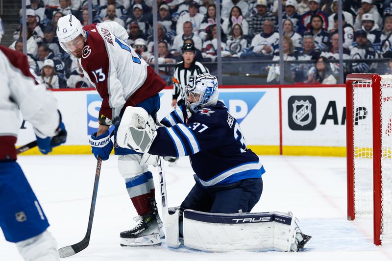 Apr 23, 2024; Winnipeg, Manitoba, CAN; Winnipeg Jets goalie Connor Hellebuyck (37) makes a save despite a screen by Colorado Avalanche forward Valeri Nichushkin (13) during the first period in game two of the first round of the 2024 Stanley Cup Playoffs at Canada Life Centre. Mandatory Credit: Terrence Lee-USA TODAY Sports