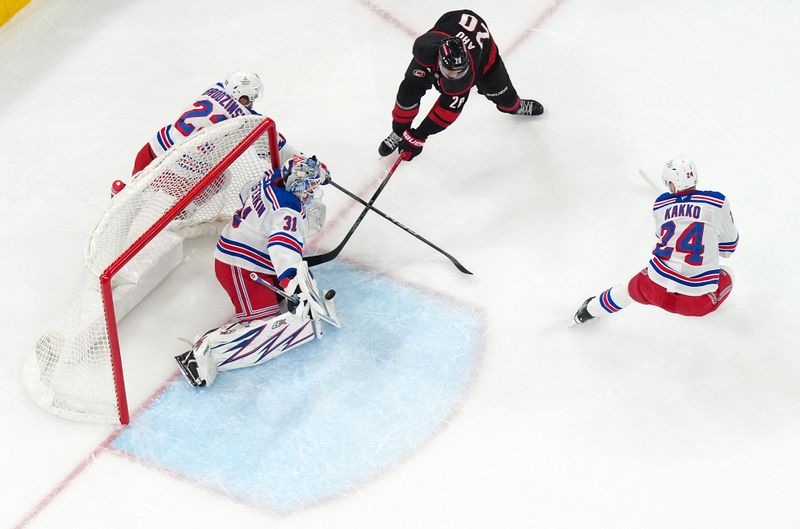 Nov 27, 2024; Raleigh, North Carolina, USA;  New York Rangers goaltender Igor Shesterkin (31) stops the scoring attempt by Carolina Hurricanes center Sebastian Aho (20) during the first period at Lenovo Center. Mandatory Credit: James Guillory-Imagn Images