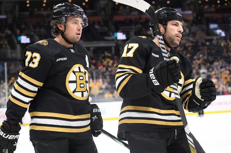 Oct 3, 2023; Boston, Massachusetts, USA;  Boston Bruins defenseman Charlie McAvoy (73) and left wing Milan Lucic (17) skate over to congratulate left wing James van Riemsdyk (21) after scoring a goal during the first period against the Washington Capitals at TD Garden. Mandatory Credit: Bob DeChiara-USA TODAY Sports