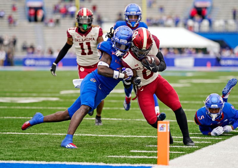 Oct 23, 2021; Lawrence, Kansas, USA; Oklahoma Sooners running back Eric Gray (0) runs against Kansas Jayhawks safety Kenny Logan Jr. (1) during the second half at David Booth Kansas Memorial Stadium. Mandatory Credit: Jay Biggerstaff-USA TODAY Sports