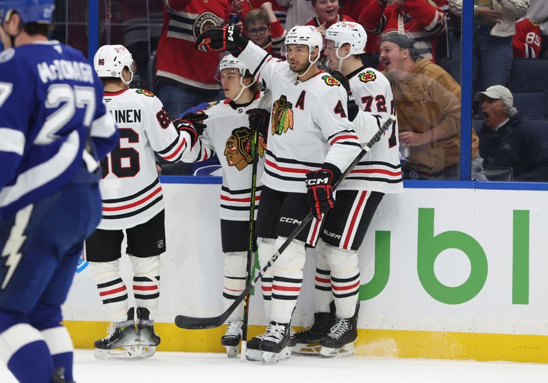 Jan 28, 2025; Tampa, Florida, USA; Chicago Blackhawks center Connor Bedard (98) is congratulated after he scored a goal against the Tampa Bay Lightning during the second period at Amalie Arena. Mandatory Credit: Kim Klement Neitzel-Imagn Images