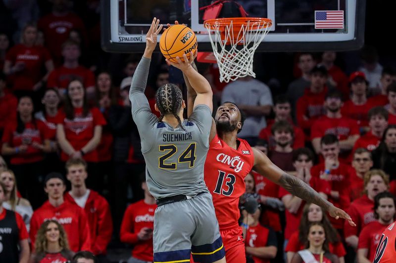 Mar 9, 2024; Cincinnati, Ohio, USA; Cincinnati Bearcats forward Jamille Reynolds (13) blocks a shot by West Virginia Mountaineers forward Patrick Suemnick (24) in the first half at Fifth Third Arena. Mandatory Credit: Katie Stratman-USA TODAY Sports