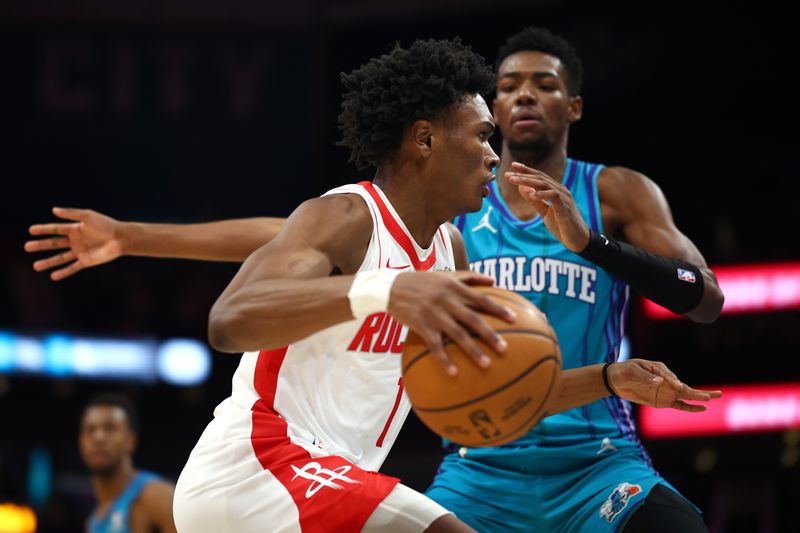 CHARLOTTE, NORTH CAROLINA - JANUARY 26: Amen Thompson #1 of the Houston Rockets drives to the basket Brandon Miller #24 of the Charlotte Hornetsduring the first quarter of the game at Spectrum Center on January 26, 2024 in Charlotte, North Carolina. NOTE TO USER: User expressly acknowledges and agrees that, by downloading and or using this photograph, User is consenting to the terms and conditions of the Getty Images License Agreement. (Photo by Jared C. Tilton/Getty Images)