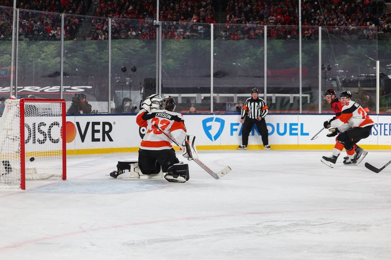 Feb 17, 2024; East Rutherford, New Jersey, USA; New Jersey Devils right wing Nathan Bastian (14) scores a goal on Philadelphia Flyers goaltender Samuel Ersson (33) during the second period in a Stadium Series ice hockey game at MetLife Stadium. Mandatory Credit: Ed Mulholland-USA TODAY Sports