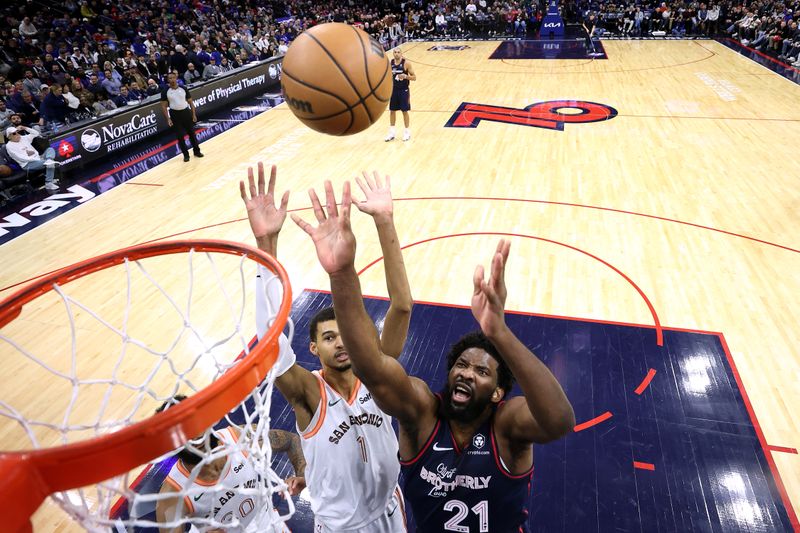 PHILADELPHIA, PENNSYLVANIA - JANUARY 22: Victor Wembanyama #1 of the San Antonio Spurs and Joel Embiid #21 of the Philadelphia 76ers reach for a rebound during the third quarter at the Wells Fargo Center on January 22, 2024 in Philadelphia, Pennsylvania. NOTE TO USER: User expressly acknowledges and agrees that, by downloading and or using this photograph, User is consenting to the terms and conditions of the Getty Images License Agreement. (Photo by Tim Nwachukwu/Getty Images)