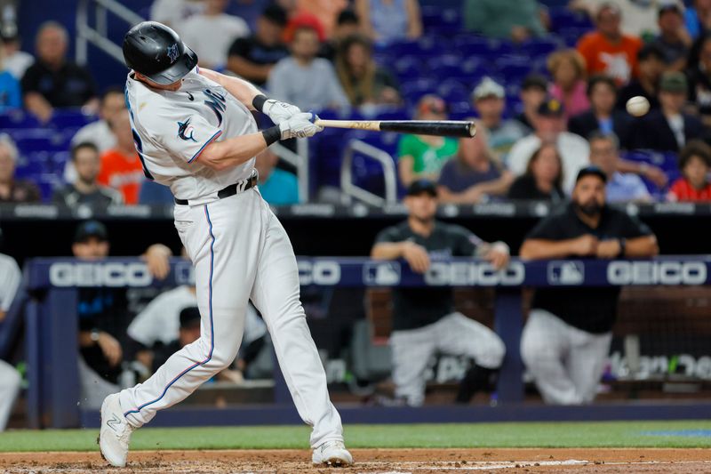 Jun 19, 2023; Miami, Florida, USA; Miami Marlins first baseman Garrett Cooper (26) hits an RBI single against the Toronto Blue Jays during the third inning at loanDepot Park. Mandatory Credit: Sam Navarro-USA TODAY Sports