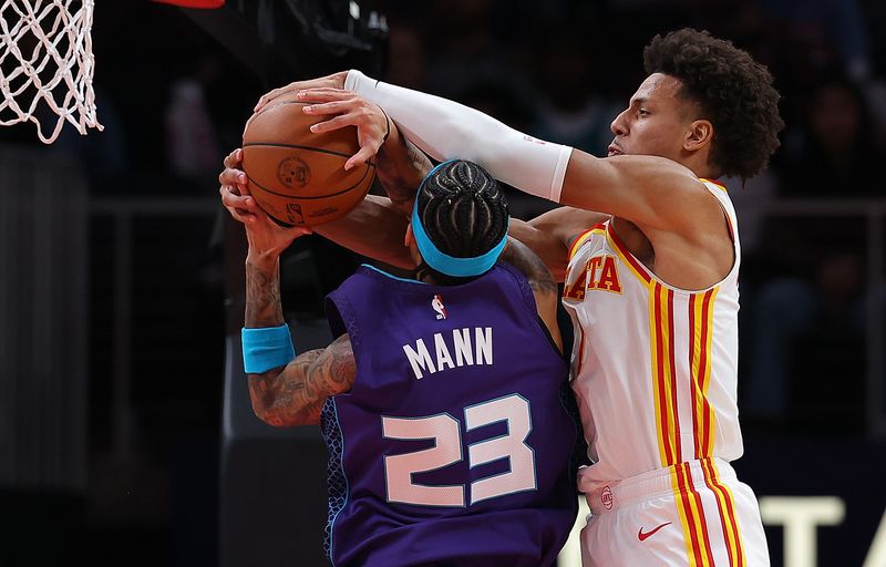 ATLANTA, GEORGIA - OCTOBER 25:  Jalen Johnson #1 of the Atlanta Hawks blocks a shot by Tre Mann #23 of the Charlotte Hornets during the fourth quarter at State Farm Arena on October 25, 2024 in Atlanta, Georgia.  NOTE TO USER: User expressly acknowledges and agrees that, by downloading and/or using this photograph, user is consenting to the terms and conditions of the Getty Images License Agreement.  (Photo by Kevin C. Cox/Getty Images)