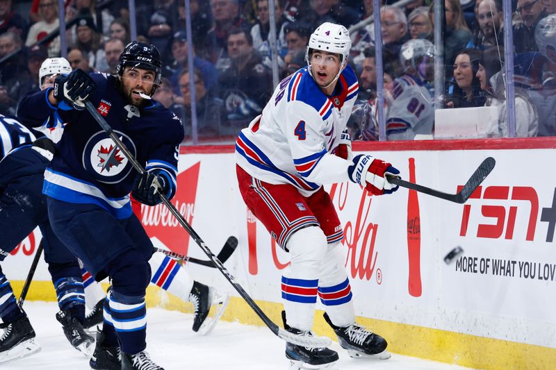 Mar 11, 2025; Winnipeg, Manitoba, CAN;  New York Rangers defenseman Braden Schneider(4) clears the puck away from Winnipeg Jets forward Alex Iafallo (9) during the second period at Canada Life Centre. Mandatory Credit: Terrence Lee-Imagn Images