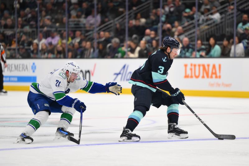 Feb 22, 2024; Seattle, Washington, USA; Seattle Kraken defenseman Will Borgen (3) plays the puck while defended by Vancouver Canucks left wing Nils Hoglander (21) during the third period at Climate Pledge Arena. Mandatory Credit: Steven Bisig-USA TODAY Sports