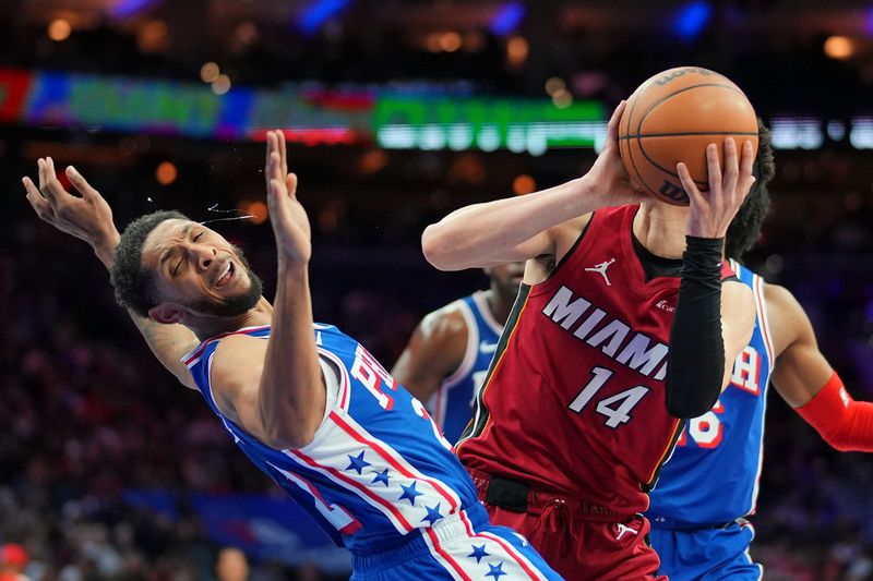 PHILADELPHIA, PENNSYLVANIA - FEBRUARY 14: Tyler Herro #14 of the Miami Heat charges into Cameron Payne #22 of the Philadelphia 76ers in the second half at the Wells Fargo Center on February 14, 2024 in Philadelphia, Pennsylvania. The Heat defeated the 76ers 109-104. NOTE TO USER: User expressly acknowledges and agrees that, by downloading and or using this photograph, User is consenting to the terms and conditions of the Getty Images License Agreement. (Photo by Mitchell Leff/Getty Images)