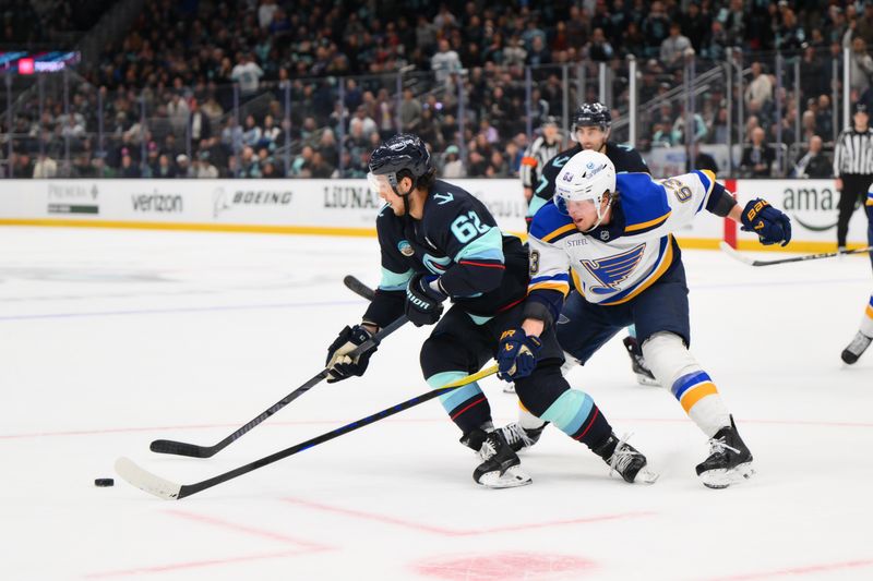 Apr 12, 2025; Seattle, Washington, USA; Seattle Kraken defenseman Brandon Montour (62) plays the puck while defended by St. Louis Blues left wing Jake Neighbours (63) during overtime at Climate Pledge Arena. Mandatory Credit: Steven Bisig-Imagn Images