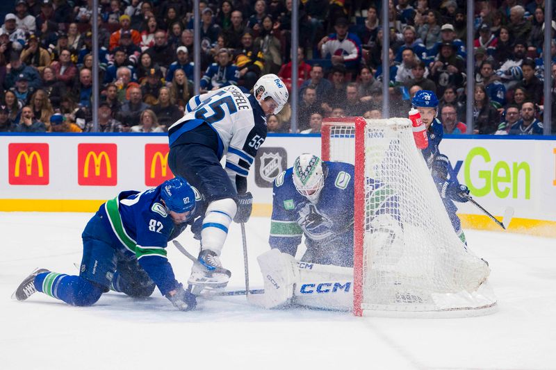 Feb 17, 2024; Vancouver, British Columbia, CAN; Vancouver Canucks defenseman Ian Cole (82) watches as goalie Thatcher Demko (35) makes a save on Winnipeg Jets forward Mark Scheifele (55) in the first period at Rogers Arena. Mandatory Credit: Bob Frid-USA TODAY Sports