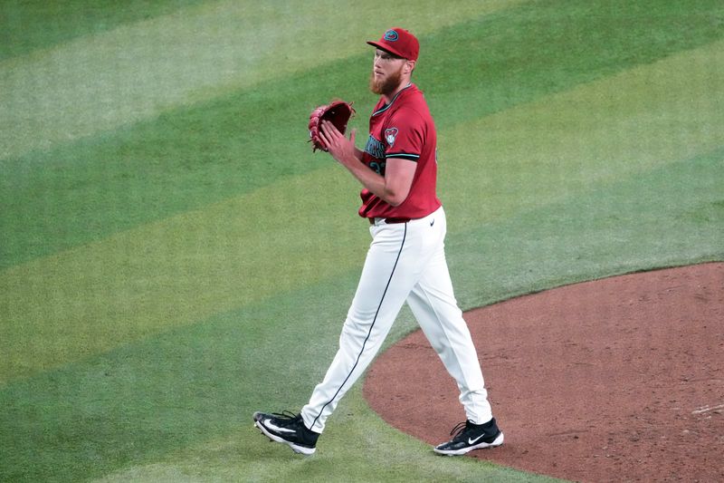 Jul 28, 2024; Phoenix, Arizona, USA; Arizona Diamondbacks pitcher A.J. Puk (33) reacts against the Pittsburgh Pirates during the seventh inning at Chase Field. Mandatory Credit: Joe Camporeale-USA TODAY Sports