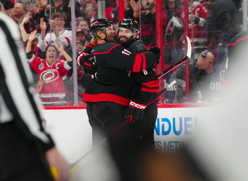 Nov 25, 2024; Raleigh, North Carolina, USA;  Carolina Hurricanes defenseman Brent Burns (8) celebrates his goal with  center Jordan Staal (11) against the Dallas Stars during the third period at Lenovo Center. Mandatory Credit: James Guillory-Imagn Images