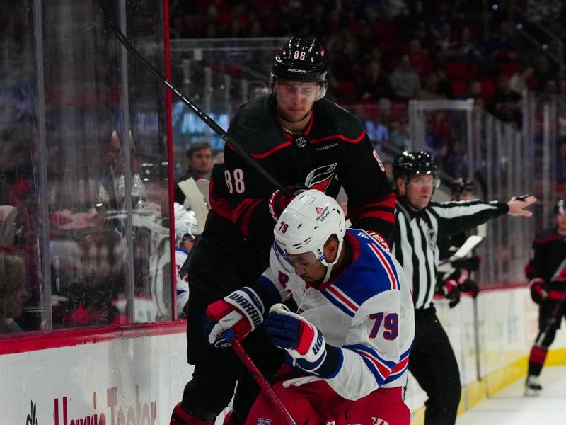 Mar 12, 2024; Raleigh, North Carolina, USA; Carolina Hurricanes center Martin Necas (88) jumps to avoid the check by New York Rangers defenseman K'Andre Miller (79) during the third period at PNC Arena. Mandatory Credit: James Guillory-USA TODAY Sports