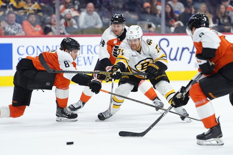 Feb 28, 2026; Philadelphia, Pennsylvania, USA; Boston Bruins left wing Viktor Arvidsson (71) reaches for the puck against Philadelphia Flyers defenseman Cam York (8) in the third period at Xfinity Mobile Arena. Mandatory Credit: Kyle Ross-Imagn Images