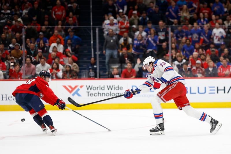 Oct 29, 2024; Washington, District of Columbia, USA; New York Rangers center Matt Rempe (73) shoots the puck as Washington Capitals defenseman Rasmus Sandin (38) defends in the second period at Capital One Arena. Mandatory Credit: Geoff Burke-Imagn Images