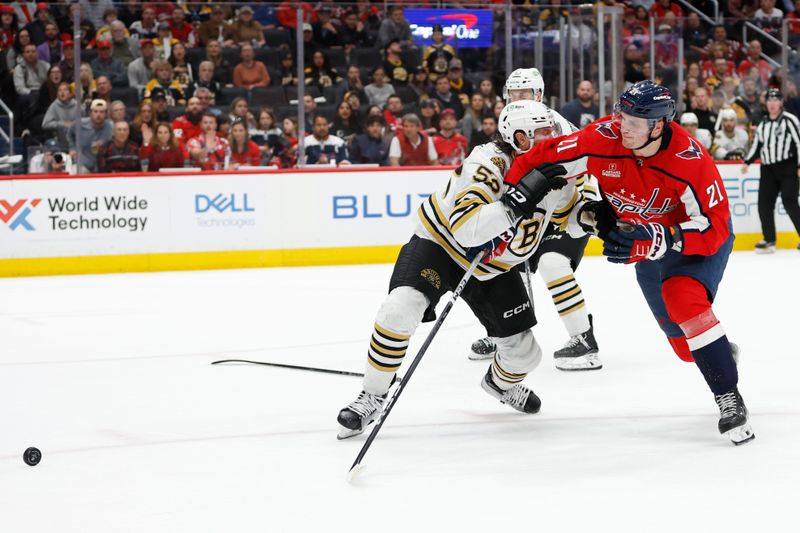 Apr 15, 2024; Washington, District of Columbia, USA; Washington Capitals center Aliaksei Protas (21) and Boston Bruins defenseman Andrew Peeke (52) battle for the puck in the third period at Capital One Arena. Mandatory Credit: Geoff Burke-USA TODAY Sports