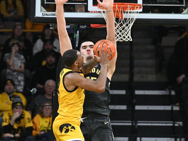 Jan 20, 2024; Iowa City, Iowa, USA; Iowa Hawkeyes guard Tony Perkins (11) attempts to shoot the ball over Purdue Boilermakers center Zach Edey (15) during the second half at Carver-Hawkeye Arena. Mandatory Credit: Jeffrey Becker-USA TODAY Sports