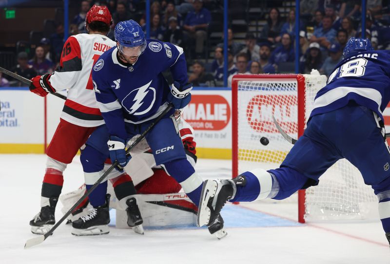 Sep 26, 2025; Tampa, Florida, USA; Tampa Bay Lightning center Zemgus Girgensons (28) scores a goal on Carolina Hurricanes goaltender Amir Miftakhov (35) during the first period at Benchmark International Arena. Mandatory Credit: Kim Klement Neitzel-Imagn Images