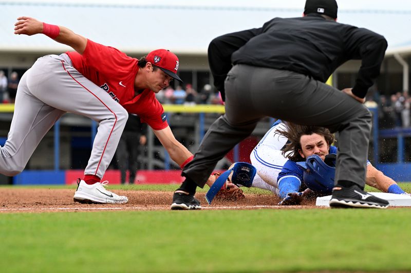 Mar 22, 2024; Dunedin, Florida, USA; Toronto Blue Jays left fielder Nathan Lukes (38) slides as Boston Red Sox third baseman Bobby Dalbec (29) places the tag in the second inning of the spring training game at TD Ballpark. Mandatory Credit: Jonathan Dyer-USA TODAY Sports