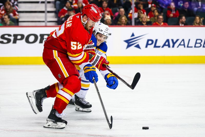 Jan 23, 2025; Calgary, Alberta, CAN; Calgary Flames defenseman MacKenzie Weegar (52) and Buffalo Sabres center Peyton Krebs (19) battles for the puck during the third period at Scotiabank Saddledome. Mandatory Credit: Sergei Belski-Imagn Images