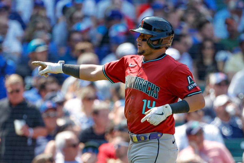 Jul 19, 2024; Chicago, Illinois, USA; Arizona Diamondbacks catcher Gabriel Moreno (14) celebrates after scoring against the Chicago Cubs during the fifth inning at Wrigley Field. Mandatory Credit: Kamil Krzaczynski-USA TODAY Sports