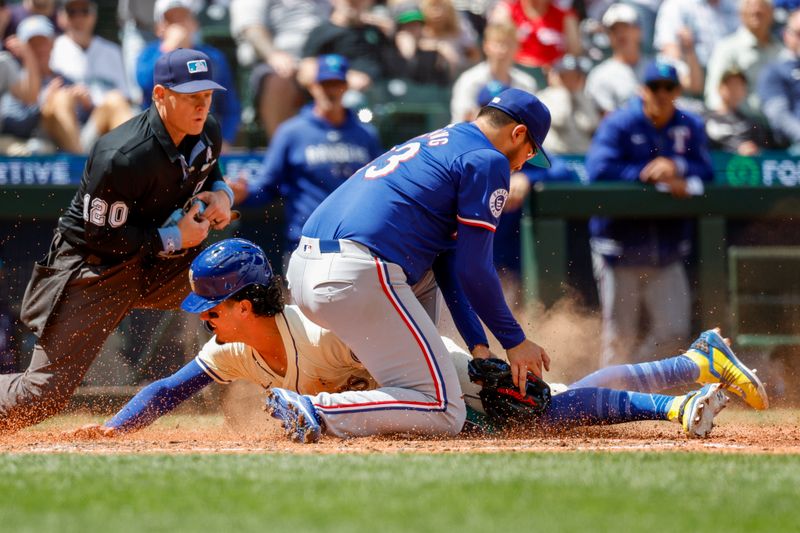 Jun 16, 2024; Seattle, Washington, USA; Seattle Mariners third baseman Josh Rojas (4) slides to score a run on a wild pitch by Texas Rangers starting pitcher Dane Dunning (33) during the fifth inning at T-Mobile Park. Mandatory Credit: Joe Nicholson-USA TODAY Sports