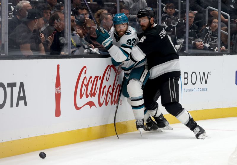 Oct 24, 2024; Los Angeles, California, USA; San Jose Sharks right wing Barclay Goodrow (23) and Los Angeles Kings defenseman Joel Edmundson (6) fight for a loose puck during the third period at Crypto.com Arena. Mandatory Credit: Jason Parkhurst-Imagn Images