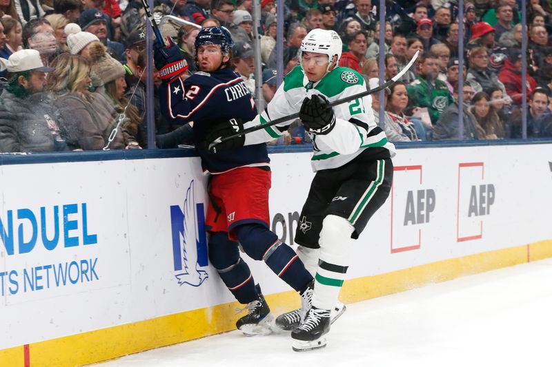 Jan 22, 2026; Columbus, Ohio, USA; Dallas Stars left wing Jason Robertson (21) checks Columbus Blue Jackets defenseman Jake Christiansen (2) during the first period at Nationwide Arena. Mandatory Credit: Russell LaBounty-Imagn Images