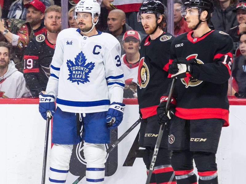 May 1, 2025; Ottawa, Ontario, CAN; Toronto Maple Leafs enter Auston Matthews (34) stands with Ottawa Senators defenseman Jake Sanderson (85) and center Shane Pinto (12) as the play is called dead in game six of the first round of the 2025 Stanley Cup Playoffs at Canadian Tire Centre. Mandatory Credit: Marc DesRosiers-Imagn Images