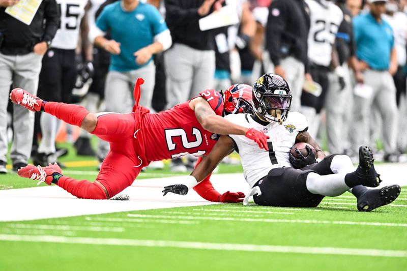 Houston Texans cornerback Steven Nelson (21) tackles Jacksonville Jaguars running back Travis Etienne Jr. (1) during an NFL football game, Sunday, Nov 26, 2023, in Houston. (AP Photo/Maria Lysaker)