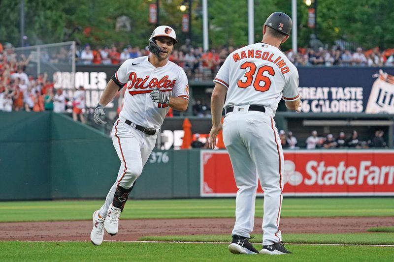 Jul 30, 2023; Baltimore, Maryland, USA; Baltimore Orioles outfielder Adam Frazier (12) greeted by coach Tony Mansolino (36) following his three-run home run in the first inning against the New York Yankees at Oriole Park at Camden Yards. Mandatory Credit: Mitch Stringer-USA TODAY Sports